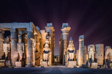 Statues of ancient Egypt illuminated at night, showcasing the grandeur of Cairo and the Pyramids of Giza.