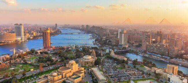 Egyptian cityscape of Cairo at sunset, showcasing vibrant colors and iconic architecture, ideal for holiday packages and tours.